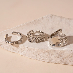 Set of three silver textured open rings with liquid metal organic texture on stone