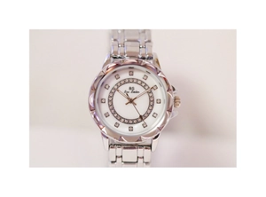Close-up of silver steel watch featuring crystal bezel and white mother of pearl dial