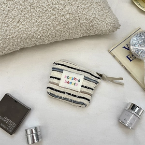 Detailed macro view of striped knit cosmetic bag with a secure zipper closure