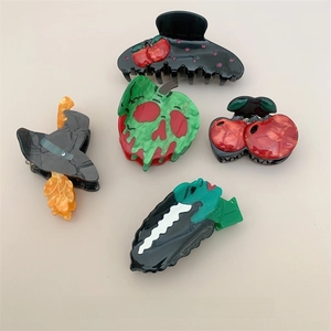 Detail shot of acetate Halloween hair claws featuring spooky cherry and poison apple designs