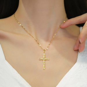 Elegant gold titanium cross pendant necklace with sparkling cubic zirconia on model