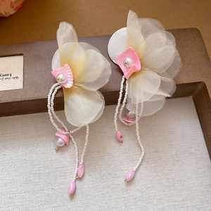 Detail of floral chiffon earrings with pearl fringe and delicate seashell accents