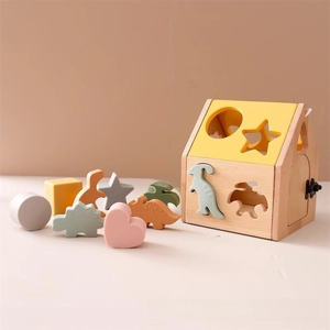 Detail of wooden shape sorter house toy with colorful dinosaur and geometric blocks