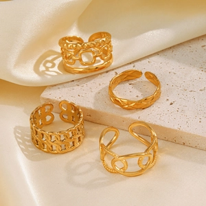 Set of four adjustable gold-plated stainless steel chain rings on white silk background