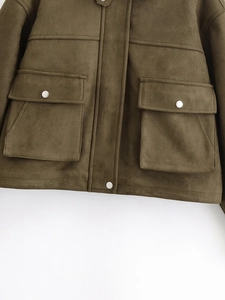 Détail d'une veste cargo en suédine marron foncé avec boutons argentés et poches à rabat