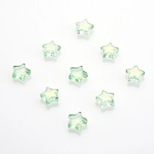 Dettaglio macro di perle di vetro a stella verde trasparente per creazione gioielli