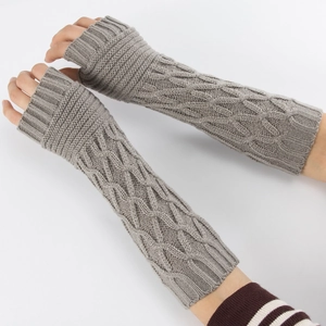 Detail of grey cable-knit fingerless arm warmers showing thick braided texture and fabric