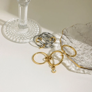 Détail de bagues superposées en acier inoxydable avec pendentif zircon et fini poli