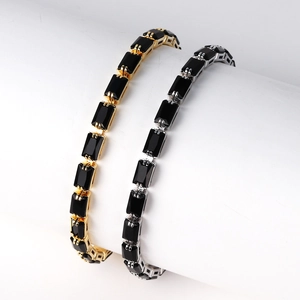 Detail of vintage style gold and silver bracelets with black rectangular gemstones
