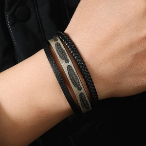 Close-up of a multi-layer woven leather bracelet with feather pattern and magnetic clasp