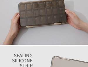 Detail of coffee-colored 7-day pill box with sealing silicone strip for moisture protection