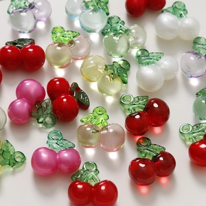 Macro view of polished colorful cherry pendants with green leaves for DIY jewelry making