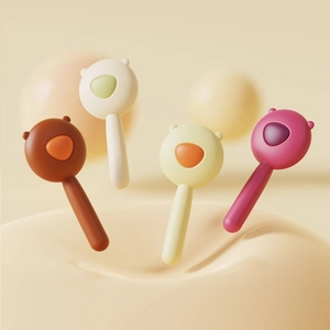 Detail of four colorful bear-shaped silicone baby training spoons floating in 3D space