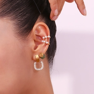 Detailed close-up of 18K gold plated C-shaped ear cuffs with pearls and zircon stones