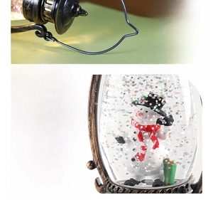 Detailed view of vintage bronze Christmas lantern with snowman and glitter inside