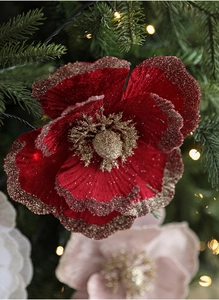 Close-up of red velvet Christmas flower with gold glitter edges on a Christmas tree