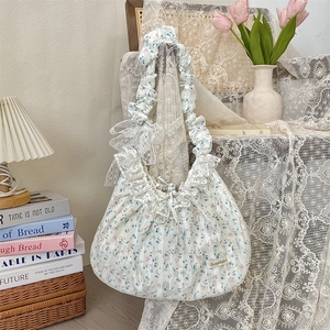 Détails d'un sac à bandoulière floral avec nœud en dentelle et bords plissés