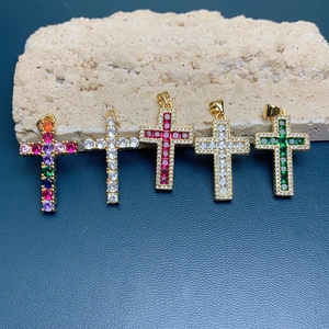 Detailed view of 18k gold plated cross pendants with colorful zircon inlay on leather
