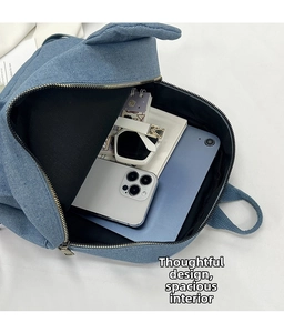 Detail view of denim backpack interior showing storage for phone and tablet