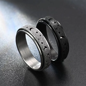 Detailed macro of stainless steel spinner rings with matte finish and hollow star moon pattern