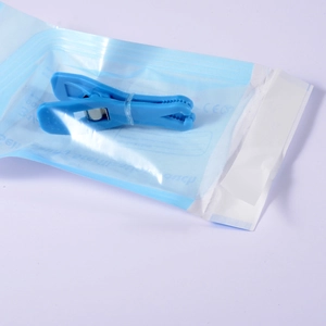 Blue acrylic piercing clamp for ear navel use in a self sealing sterilization pouch with CE