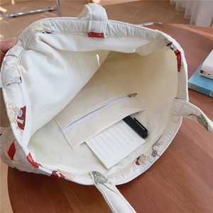 Quilted tote bag interior view showing large capacity compartment and zipper inner pocket