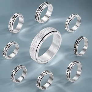 Macro detail of nine rotating spinner rings with stars, moon, and heart engraved patterns