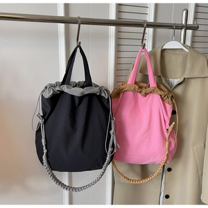 Dettaglio della grande borsa a secchiello in nylon con chiusura a coulisse a contrasto