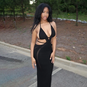 Detailed close-up of the backless halter design and hollowed-out knit texture of this black dress
