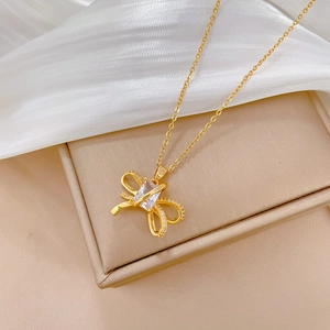 Macro shot of gold bow necklace pendant with cubic zirconia on champagne display box