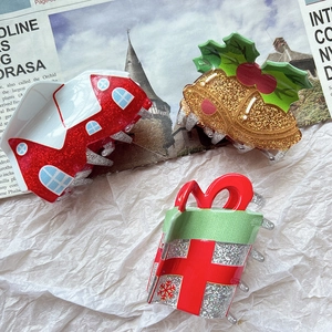 Detail von Weihnachts-Haarklammern mit glitzerndem Haus, goldenen Glocken und Geschenkbox
