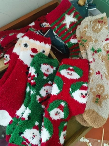 Close-up of festive coral fleece socks with Santa and gingerbread man patterns