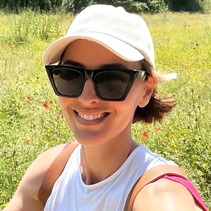 Fashionable oversized square black sunglasses and white baseball cap worn by model outdoors
