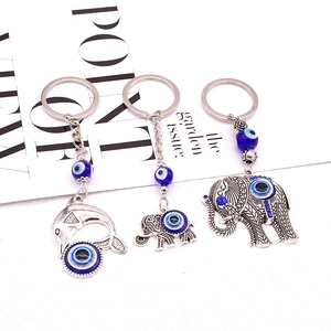 Detail of tribal elephant and dolphin keychains with Turkish blue evil eye beads