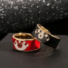 Detail of red and black enamel Evil Eye wide rings with polished gold-plated finish