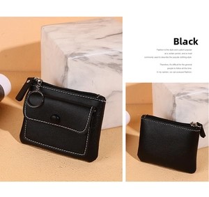 Detail view of black lychee leather coin purse with white stitching and key ring