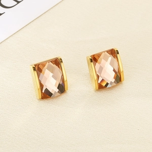 Macro detail of 18K gold plated square earrings with champagne crystal and brushed texture
