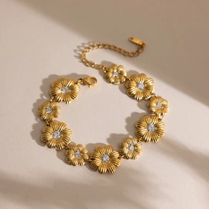 Detail eines goldenen Gänseblümchen-Armbands mit Zirkonia und einem Karabinerverschluss