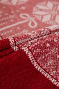 Macro shot of red and white knitted snowflake patterns on a festive jacquard tablecloth