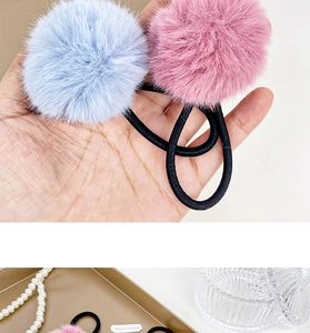 Detailed view of plush pompom hair ties in blue and pink with high elasticity bands