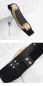 Detail of black elastic waist belt with triple gold chains and metallic pyramid studs