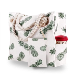 Detail of canvas tote bag with pineapple print showing side pocket and rope handle