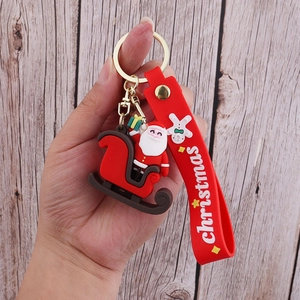 Close-up of PVC Santa on sleigh keychain with red silicone Christmas wrist strap