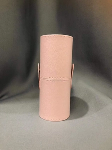 Pink leather makeup brush holder with side button closure and cylindrical shape detail