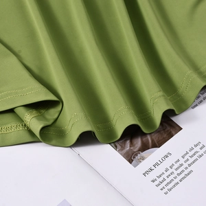 Detailed close-up of green summer dress hem featuring high-quality double-needle stitching