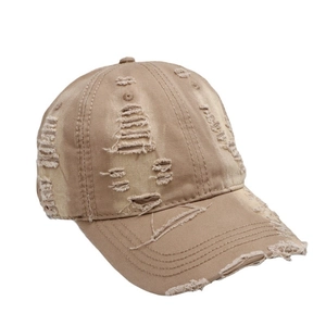 Distressed vintage khaki baseball cap with ripped details and frayed brim on white background