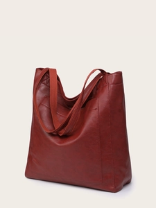 Vue détaillée du sac cabas vintage marron-rouge avec texture cuir souple et poche externe