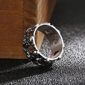 Macro detail of the silver-tone double row skull design on vintage steel ring
