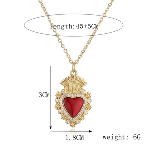 Dettaglio della collana con ciondolo a cuore dorato, gemma rossa e dimensioni