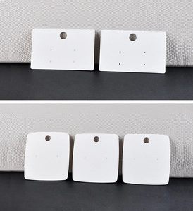 Detailed view of white jewelry display cards with pre-punched holes for earrings and pins